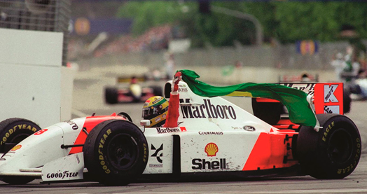 Senna a festejar com a bandeira do Brasil a bordo de um McLaren