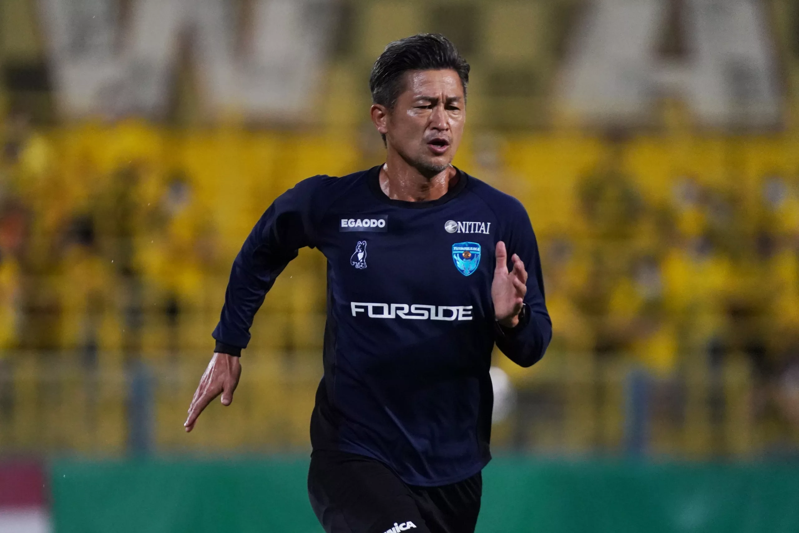jogador de futebol Kazuyoshi Miura a correr
