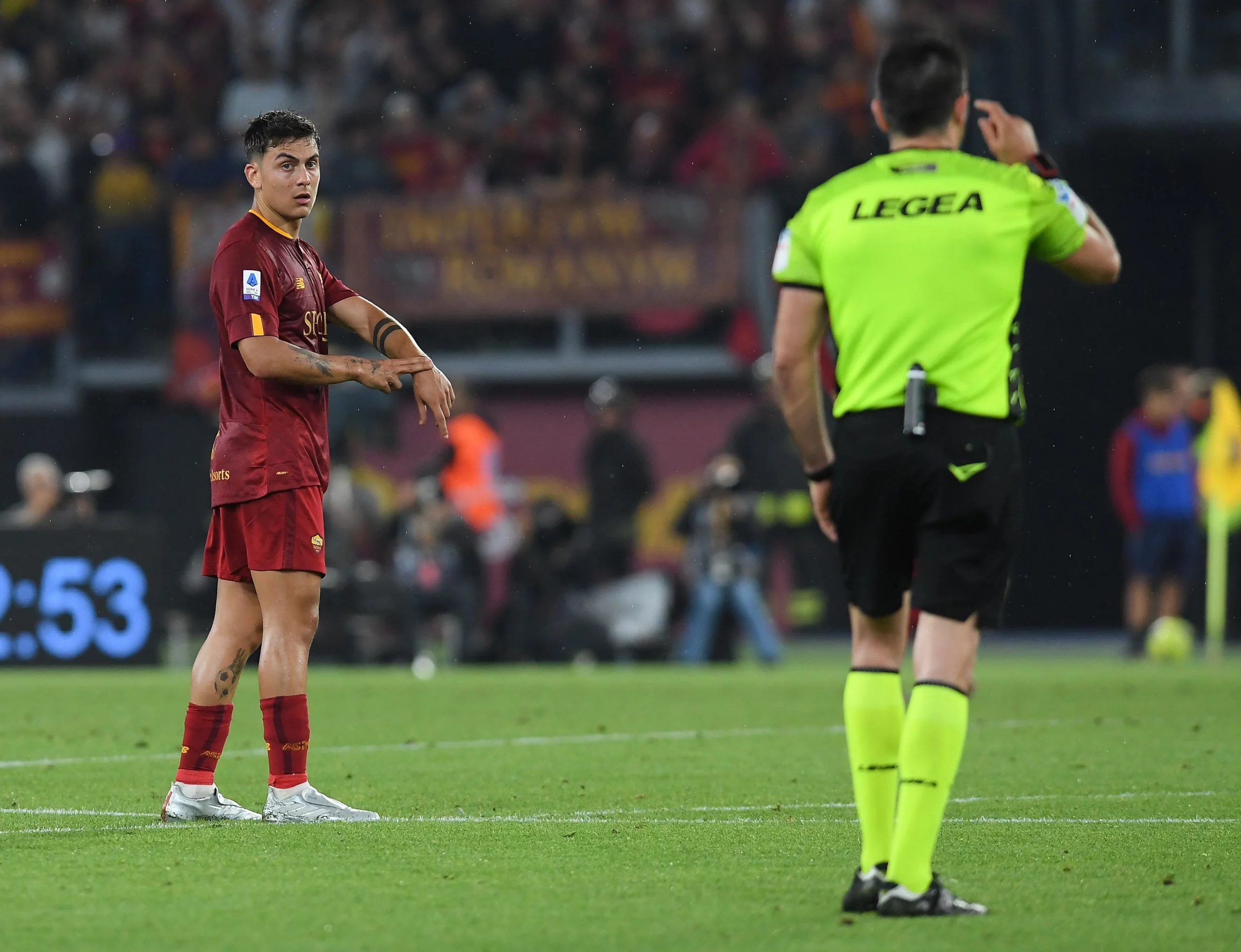 jogador Dibala do Roma a apontar para o pulso dando indicação ao arbitro do tempo de jogo